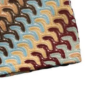 Macro detail of bohemian wave pattern crochet knit fabric with colorful hollow texture