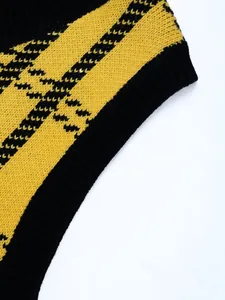 Detail of yellow and black checkered knit fabric with ribbed hem on a V-neck sweater vest
