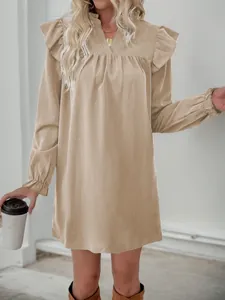 Detail of ruffled stand collar and V-neckline on light khaki long sleeve mini dress