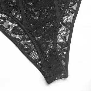 Detailopname van bloemenkantpatronen en de elastische rand van de zwarte bodysuit