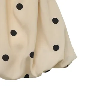 Dettaglio dell'orlo a sbuffo a pois con tessuto crema e cuciture precise sul top Y2K