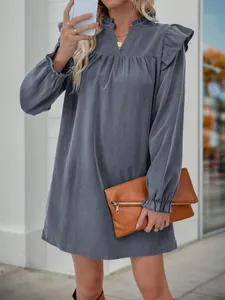 Detail of ruffle trim on the V-neck and cuffs of a loose grey-blue long sleeve dress