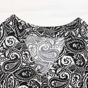 Détail de l'encolure en V avec motif paisley sur robe à manches longues noir et blanc