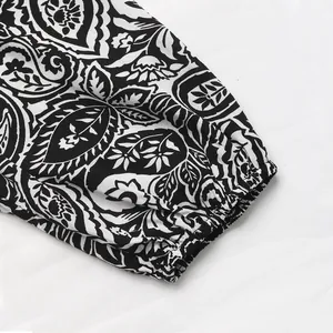 Détail rapproché des poignets élastiques à motif cachemire sur cette robe en V