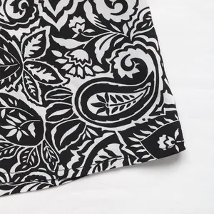 Détail de l'imprimé floral cachemire noir et blanc et coutures fines sur une robe à col en V