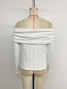 Detail of white ribbed knit fabric showing fine vertical texture on back of off-shoulder top