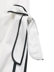 Detailed close-up of white sweatshirt waist tie with black contrast piping and fabric texture