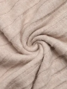 Close-up of beige ribbed knit fabric showing soft vertical texture and premium quality