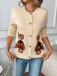 Détail d'un cardigan en maille avec broderies d'ours et boutons en écaille