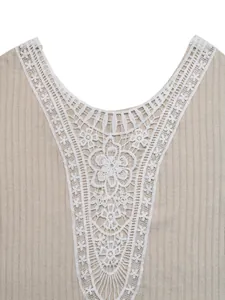 Gros plan sur la maille et la dentelle florale délicate du haut beige à col en V