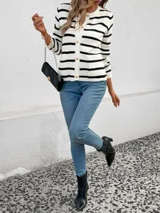 Détail du cardigan rayé noir et blanc avec des boutons dorés rétro et texture tricotée