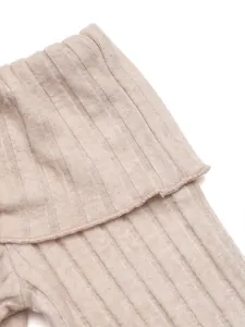 Close-up of beige knit fabric showing high-quality ribbed texture and soft material