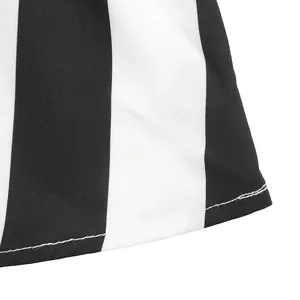 Macro view of the hem stitching on a black and white vertical striped short sleeve shirt