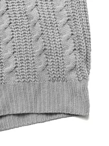 Dettaglio della maglia a trecce grigia e del polsino a coste su un maglione vintage minimal