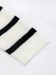 Gros plan sur la texture tricotée à rayures noires et blanches et le tissu doux du poignet