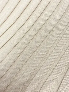 Gros plan sur la maille côtelée beige élégante et texturée de cette robe longue