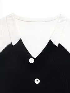 Close-up of contrast V-neck collar and white buttons on black ribbed knit sweater