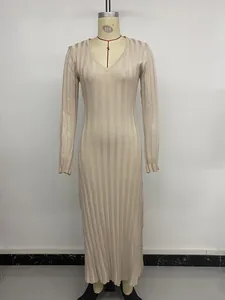 Détail d'une robe longue élégante en maille à col en V, texture côtelée et manches longues