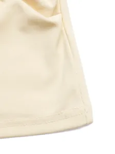 Détail macro du tricot à fines côtes et des coutures de haute qualité sur le haut ivoire