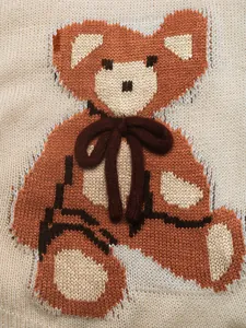 Détail de maille avec motif ours brun et nœud papillon en peluche 3D décoratif