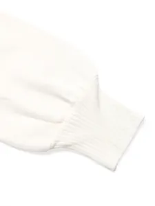 Close-up detail of white knitted sweater sleeve with elastic ribbed cuffs and soft texture