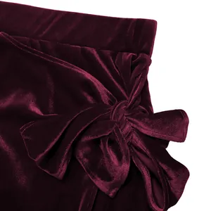 Détail du nœud élégant sur jupe en velours bordeaux avec texture soyeuse luxueuse