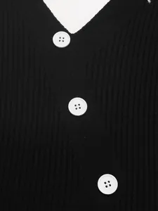 Detailed close-up of a black ribbed V-neck knit sweater with white round buttons