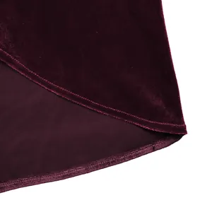 Détail du tissu en velours rouge foncé montrant une texture lisse et des coutures de qualité