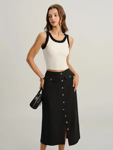 Detail of high-waisted black midi skirt with buttons and pockets for women