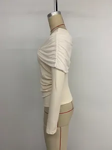 Vue détaillée du design torsadé et de l'épaule froncée sur le haut en maille beige
