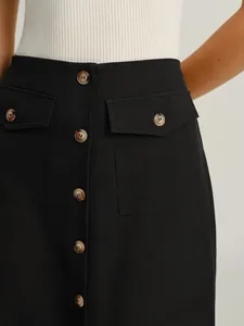 Close-up of elegant black straight skirt with vintage buttons and side flap pockets