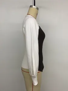 Detail of slim-fit knit sweater showing black body and white sleeves with ribbed texture