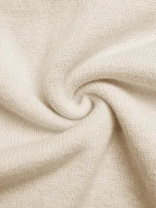 Close-up of the cream knit fabric showing delicate texture and soft material on the sweater