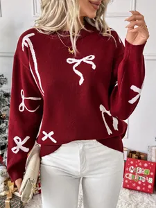 Close-up of wine red knit sweater featuring white bow patterns and beaded details