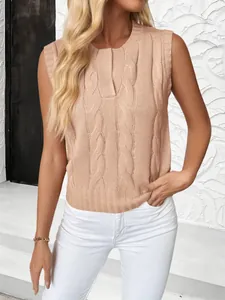 Detail of apricot cable knit vest showing round neck and intricate braided texture