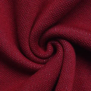 Macro shot of dark red knitted fabric with soft spiral drapes and fine texture