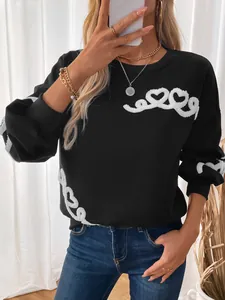Detail of black fleece sweatshirt featuring white chenille heart and spiral embroidery