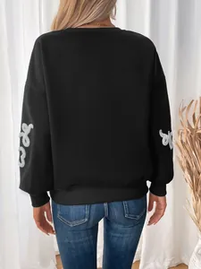 Detail of black crewneck sweatshirt with white towel embroidery on the long sleeves
