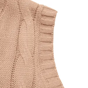 Close-up of beige cable knit pattern and ribbed hem on a sleeveless sweater vest
