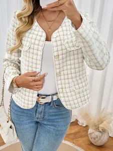Detailopname van elegant tweed vest met parelafwerking en gouden reliëfknoppen