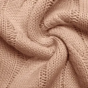 Close-up of premium cable knit texture on a soft pink sleeveless sweater vest