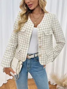 Detail van de tweed textuur met parelafwerking en gouden knopen op deze nette jas