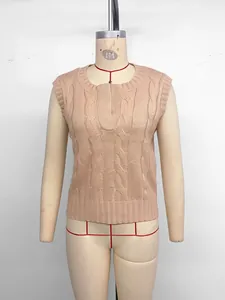 Close-up of peach cable knit vest featuring a round neck with unique small V-notch detail