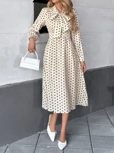 Elegante abito midi beige a pois con scollo a fiocco e maniche lunghe da donna
