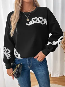 Detail of white chenille heart embroidery on black fleece crewneck sweatshirt sleeves