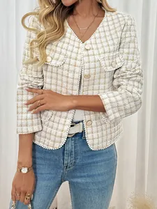 Detailopname van tweed vest met witte parelafwerking en gouden metalen knopen