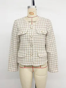 Detailopname van tweed jasje met parelafwerking en gouden knopen op de voorkant van de jas