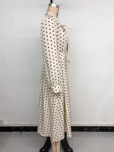 Dettaglio dell'abito midi a pois con colletto a fiocco e vita stretta per un look elegante