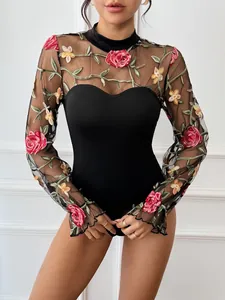 Detailed close-up of colorful floral rose embroidery on black lace bodysuit mesh sleeves