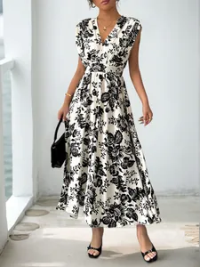 Detail shot of the V-neckline and black artistic floral print on white maxi dress